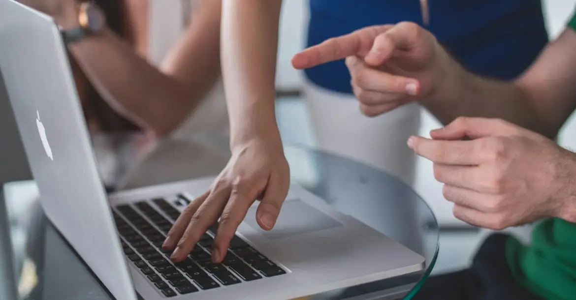 person touching and pointing MacBook Pro